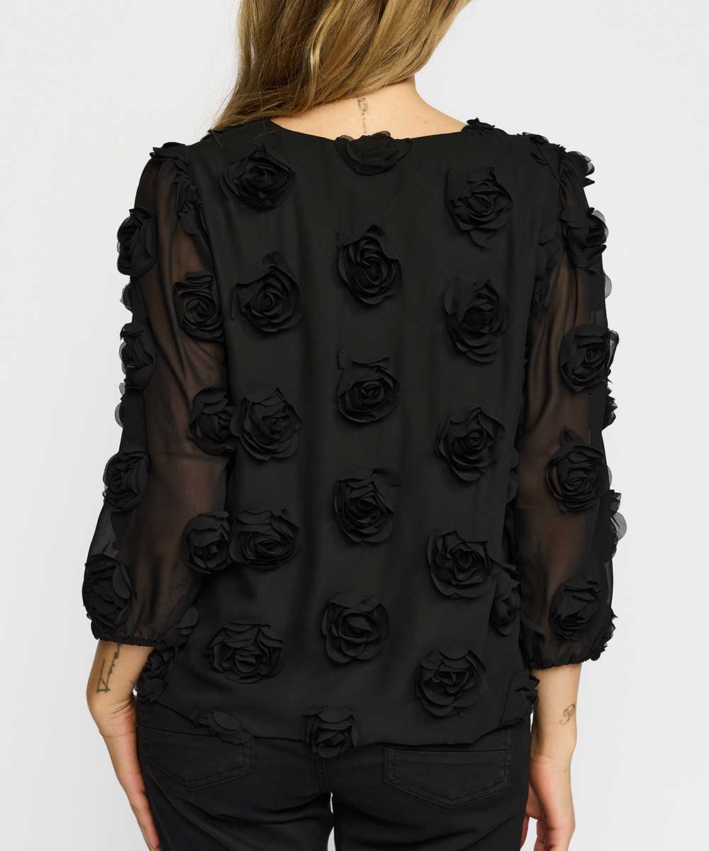 blus med blommor baksida