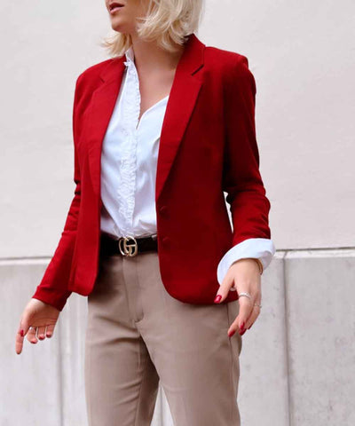 modell i röd kavaj, vit skjorta och beige byxa