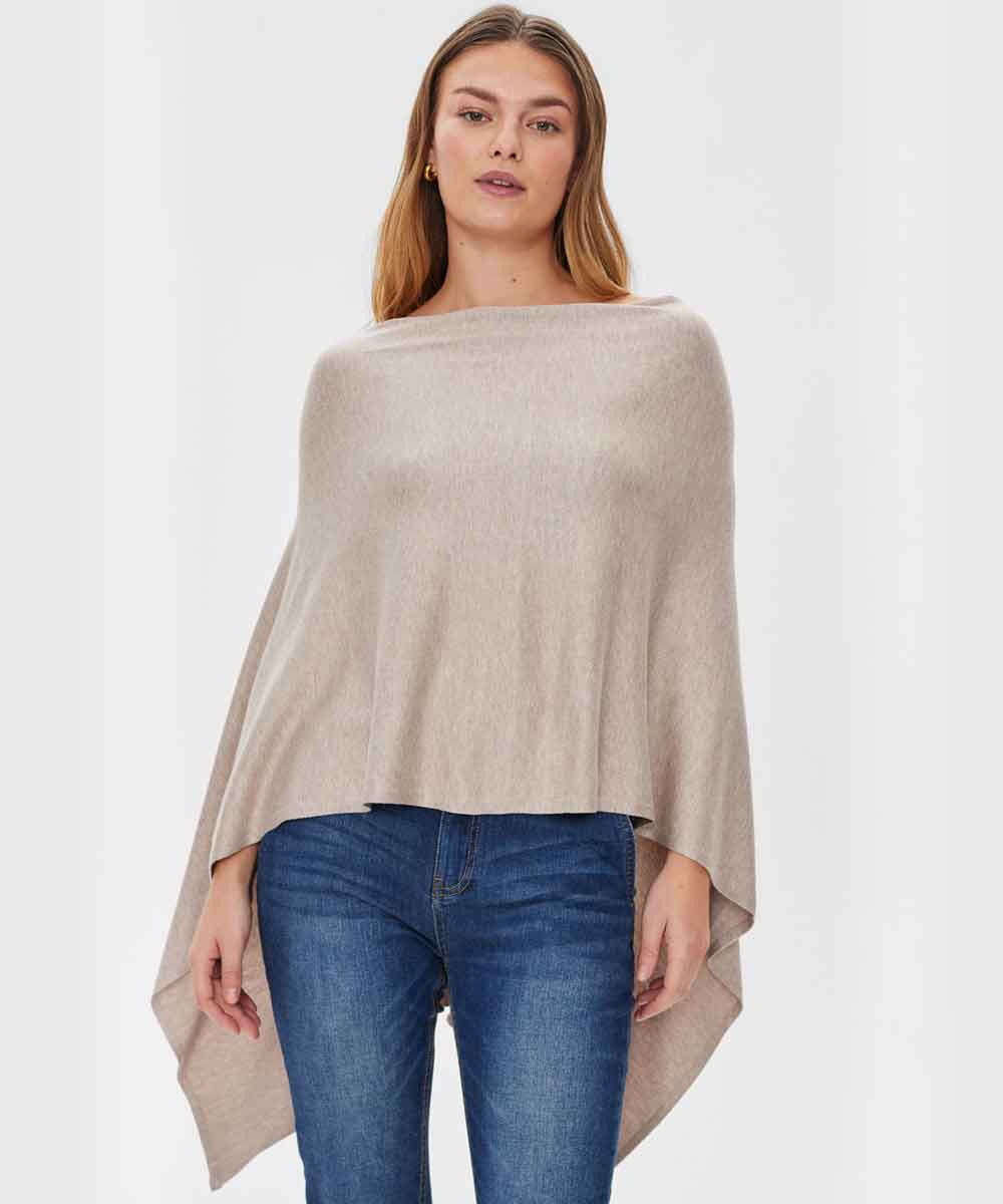 Modell i beige poncho och jeans