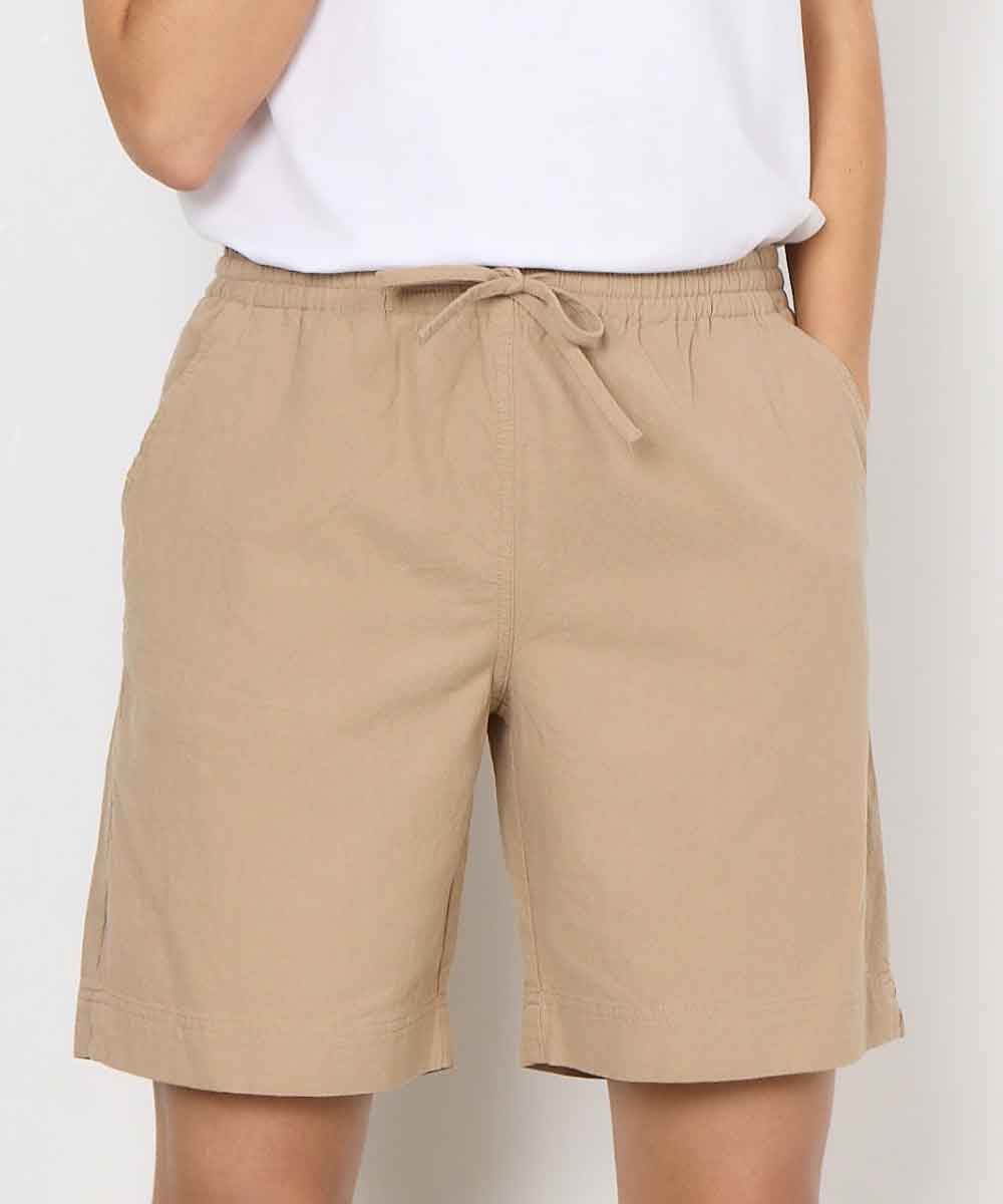 modell i camelfärgade shorts