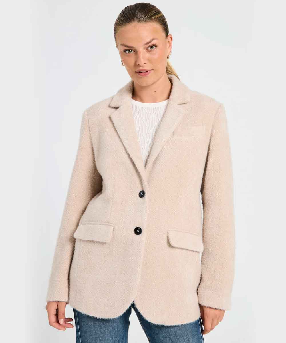 Modell i beige kavajjacka