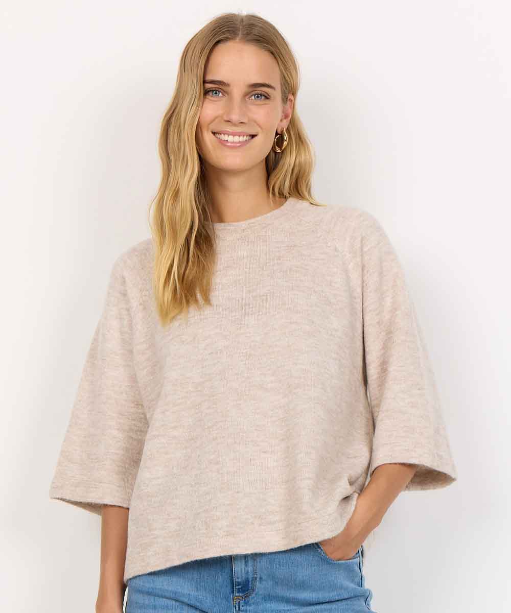 Modell i beige stickad tröja