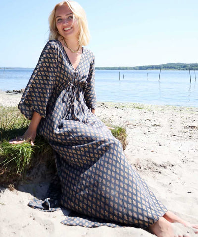 modell på stranden i grå klänning