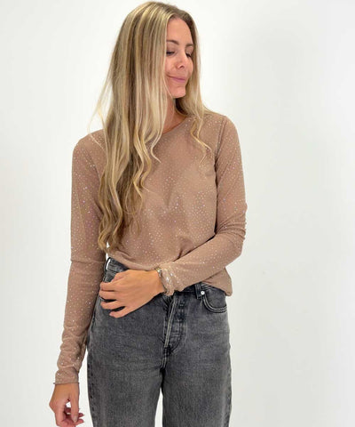 modell i beige topp med glitter