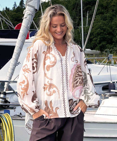 Modell i blus med brunt/beige mönster