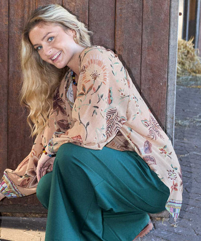 modell i beige blus och grön byxa