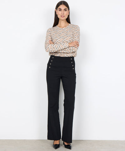 Modell i svart byxa med knappar