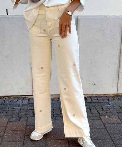 beige byxa med broderade blommor