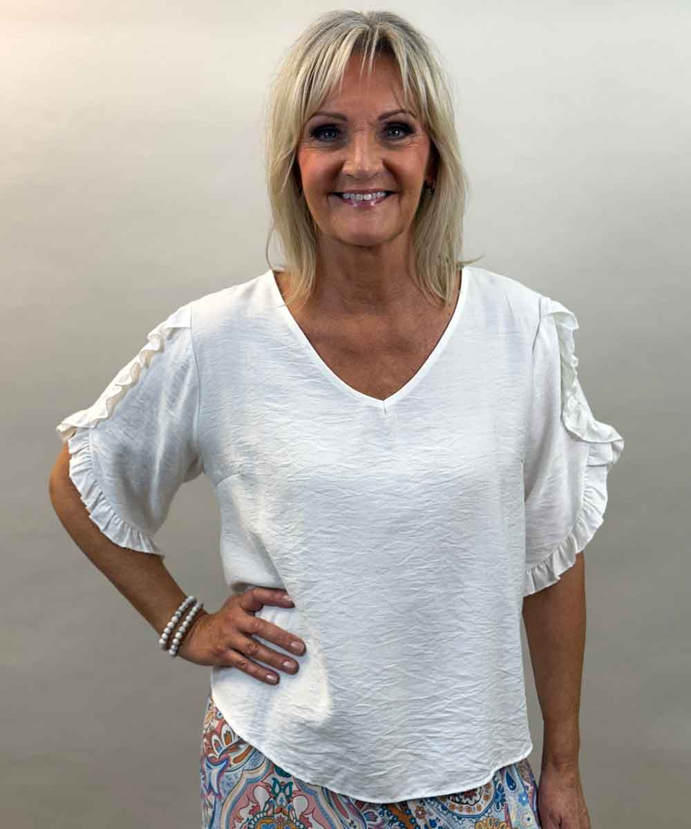 Vit blus med volang