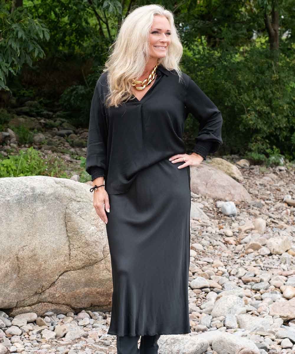 modell i svart satinblus och kjol