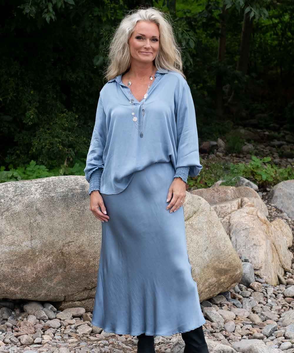 modell i blå satinblus och kjol