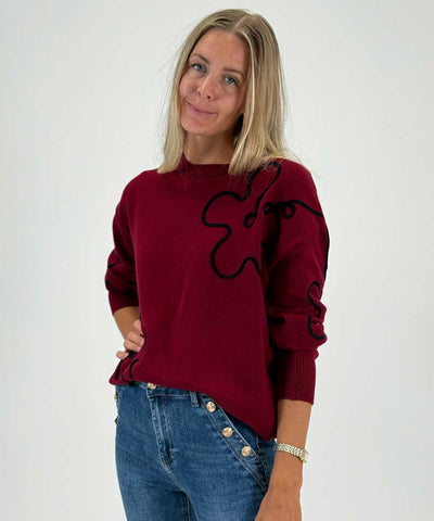 vinröd tröja och jeans