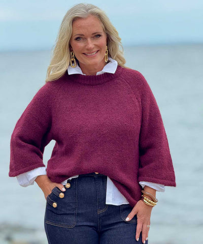 Vinröd tröja och jeans