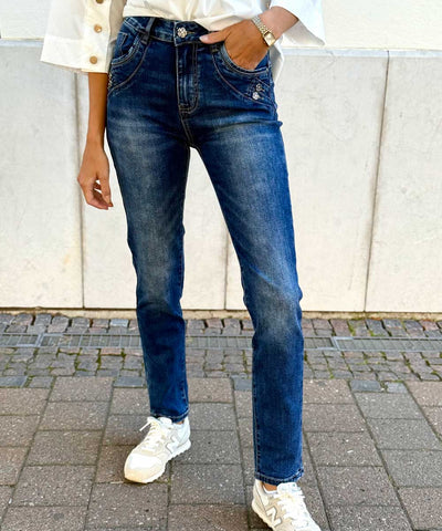 Blå jeans med blomknapp