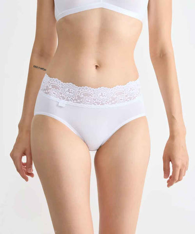 Modell i vita trosor med spets