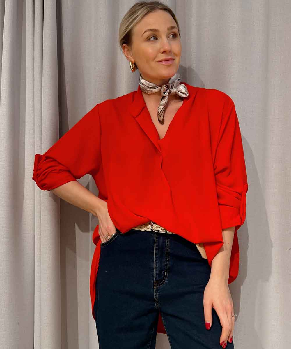 modell i röd tunika och jeans