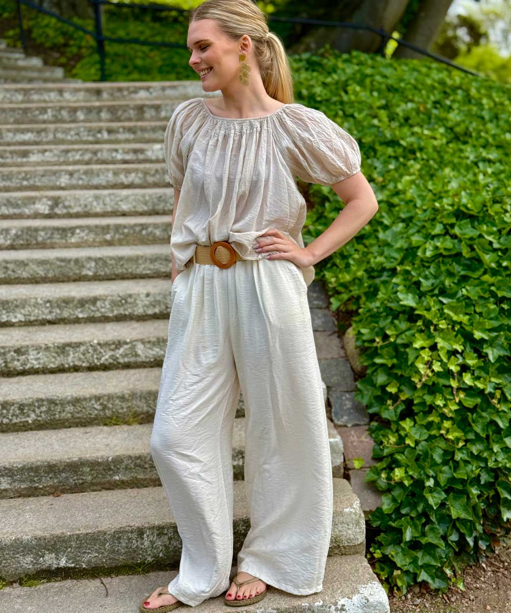 Modell i beige byxa och blus